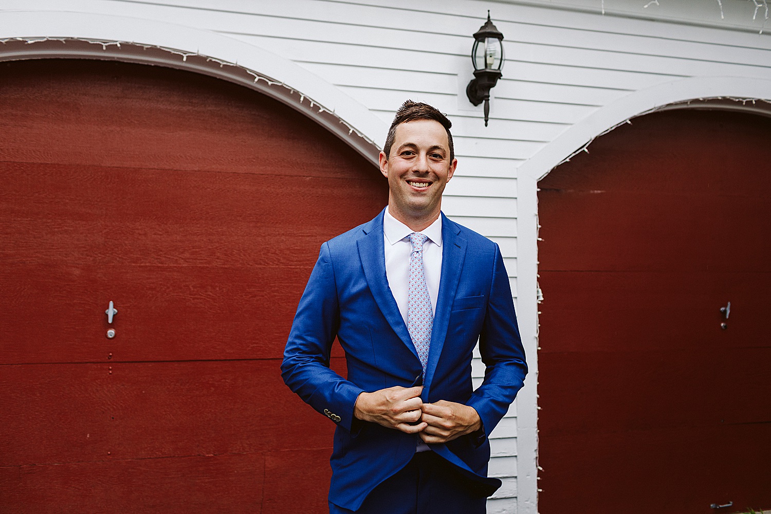 groom buttoning jacket at Maine wedding at Granite Ridge Estate & Barn