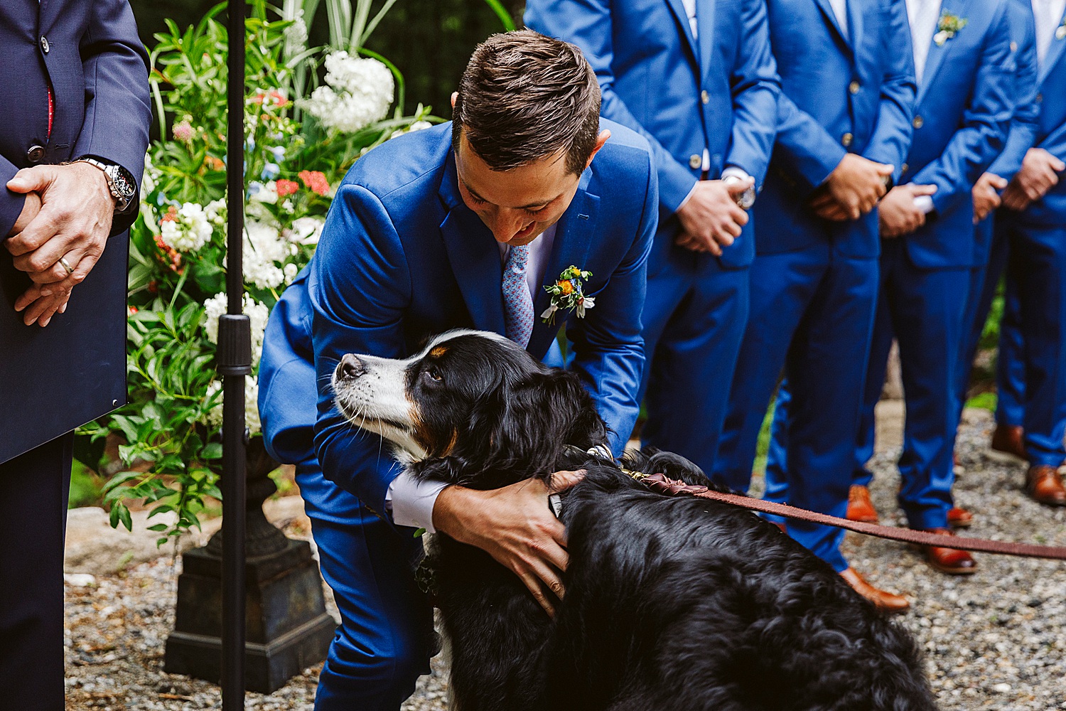 groom hugging his dog at wedding ceremony