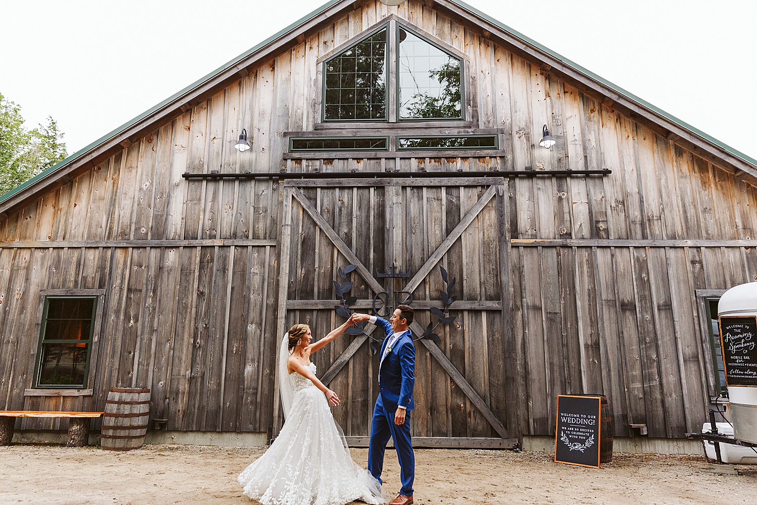 Bride and groom dancing in front of Maine wedding barn
