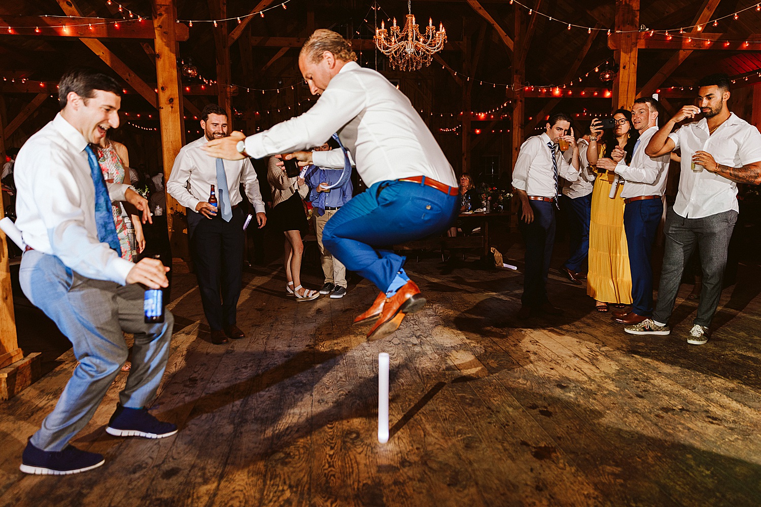 man jumping over glow stick at Maine wedding