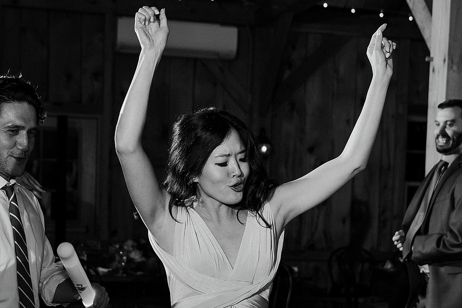 woman throwing her arms up as she dances at Maine wedding at Granite Ridge Estate & Barn
