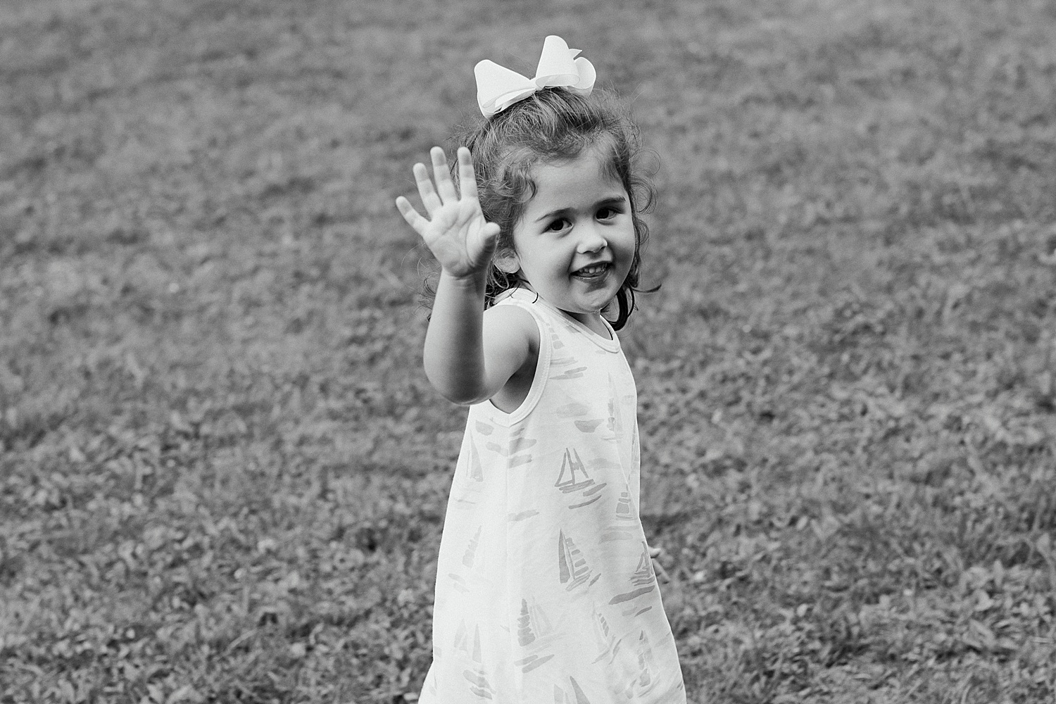 little girl waving at the camera at the end of portrait session in Sargentville, Maine