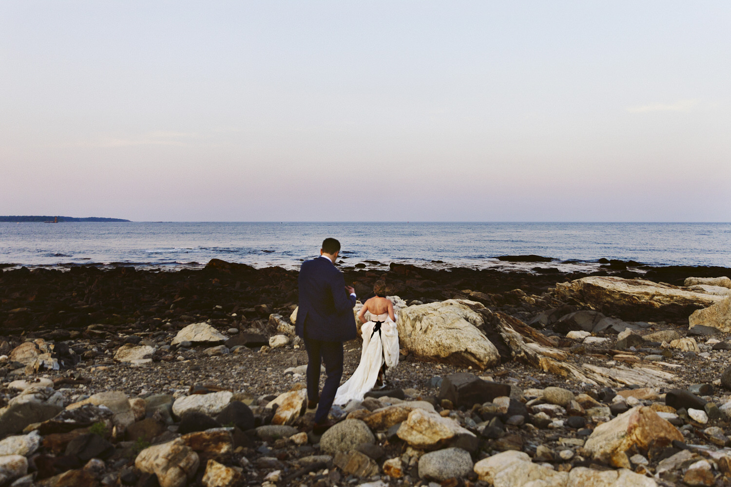 bride and groom on cliffs at sunset during wedding at Seacoast Science Center in Rye, NH