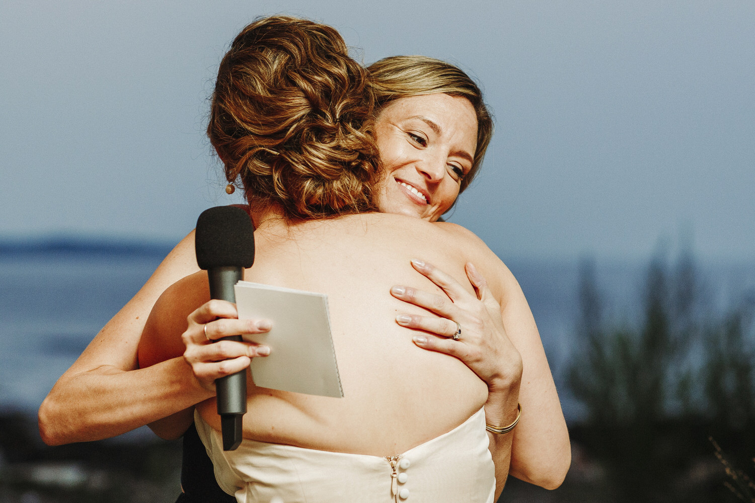 bride hugging maid of honor after toast