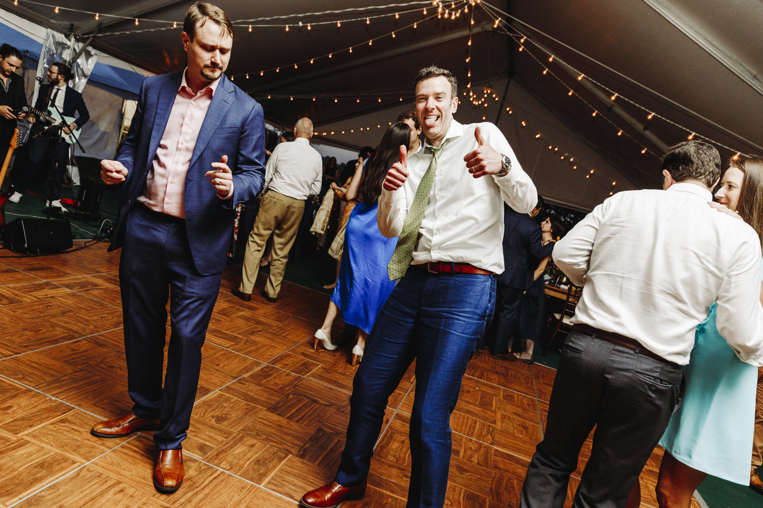 groom gives a thumbs up on dance floor at wedding