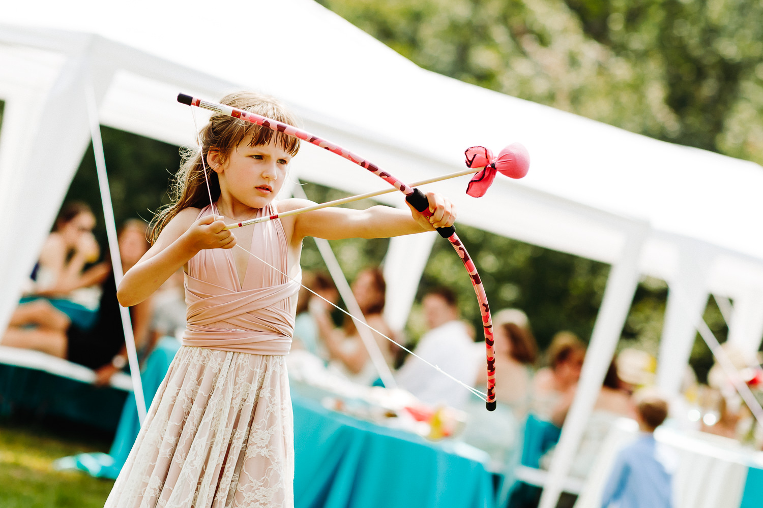 flower girl with bow and arrow at backyard wedding in Northport, Maine