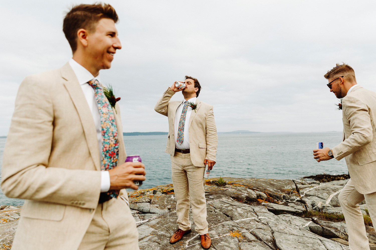 groomsmen drinking beer on cliffs in Bar Harbor