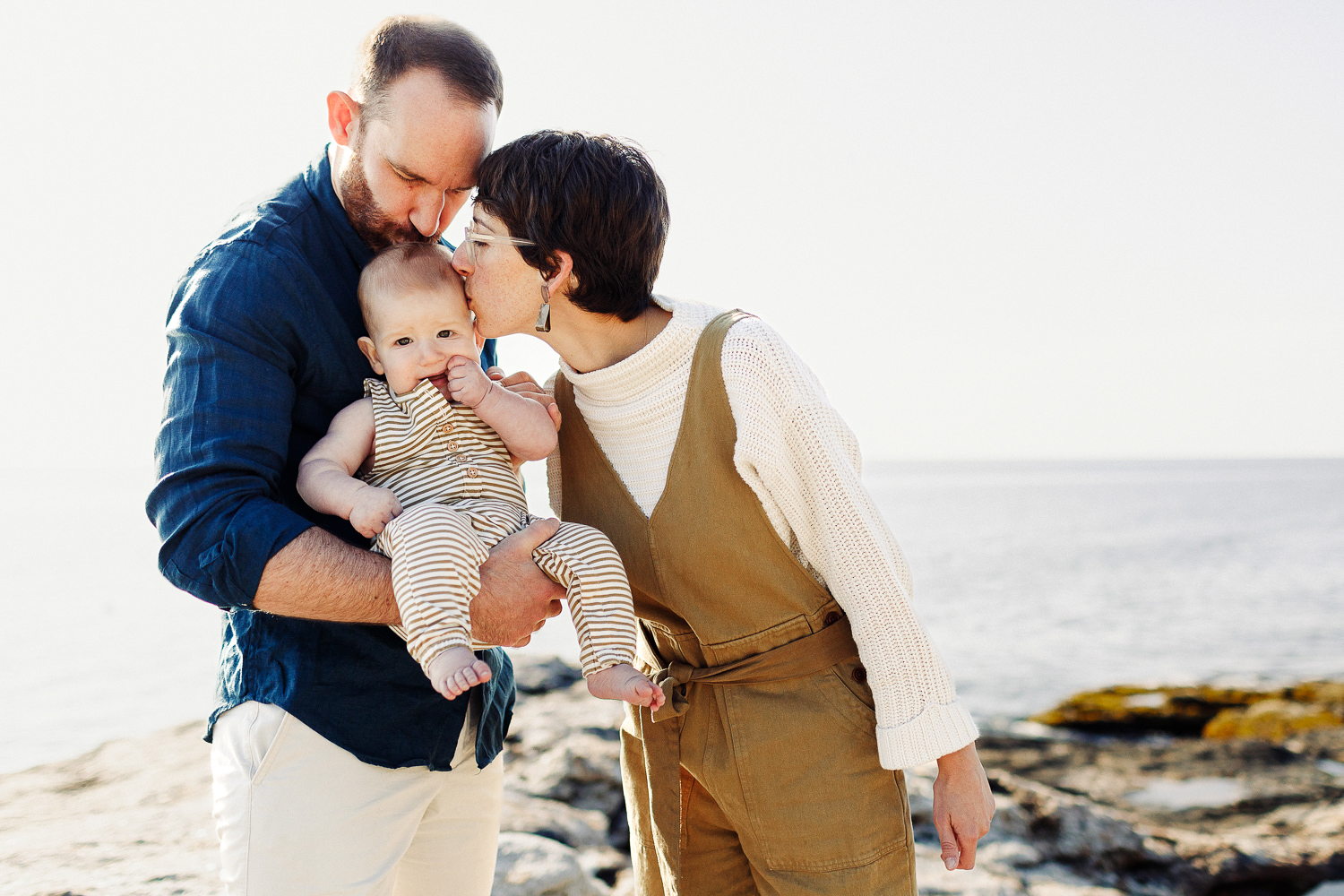 parents kissing their baby during summer portraits in Bristol, Maine