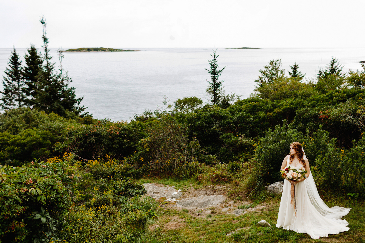 Bride standing by ocean at Orr's Island Maine Wedding