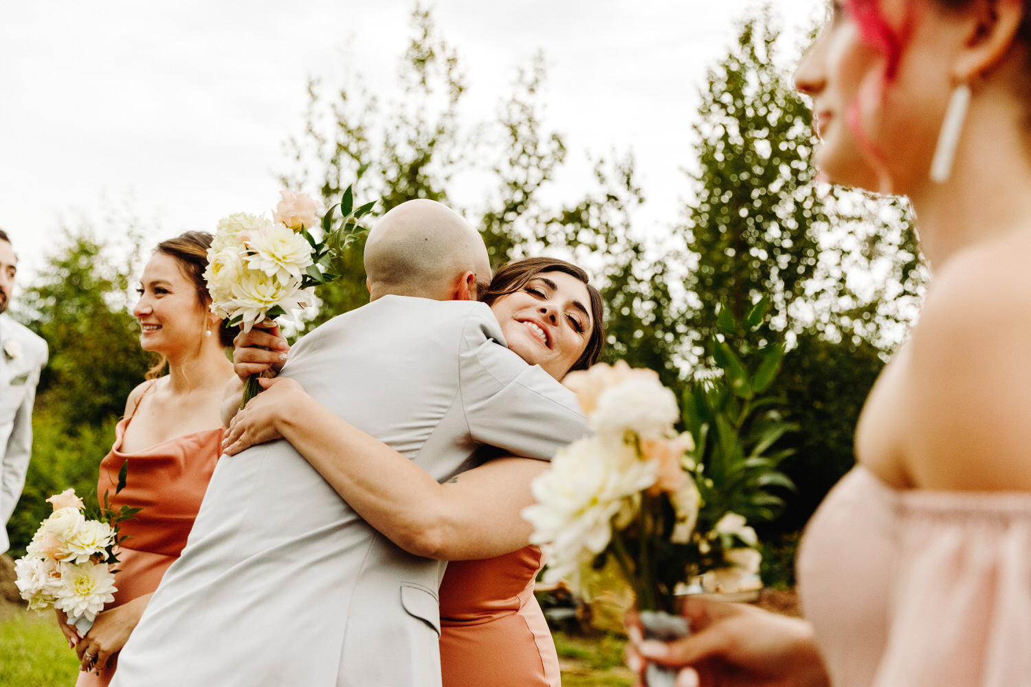 Groom hugs a bridesmaid after the wedding ceremony