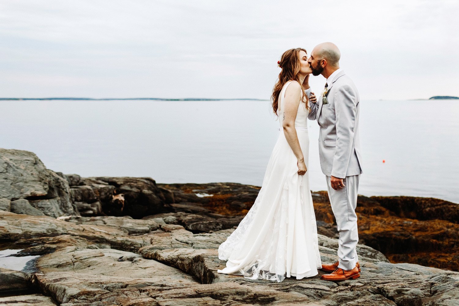bride and groom kissing on cliffs at Orr's Island Maine Wedding