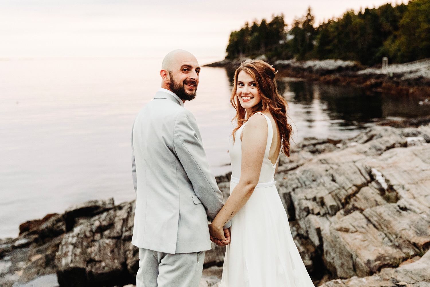 bride and groom looking over their shoulders and smiling during Orr's Island Maine Wedding