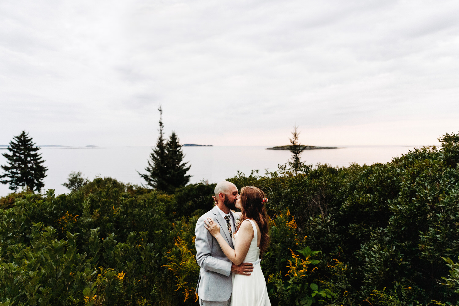 bride and groom kissing by ocean on Orr's Island