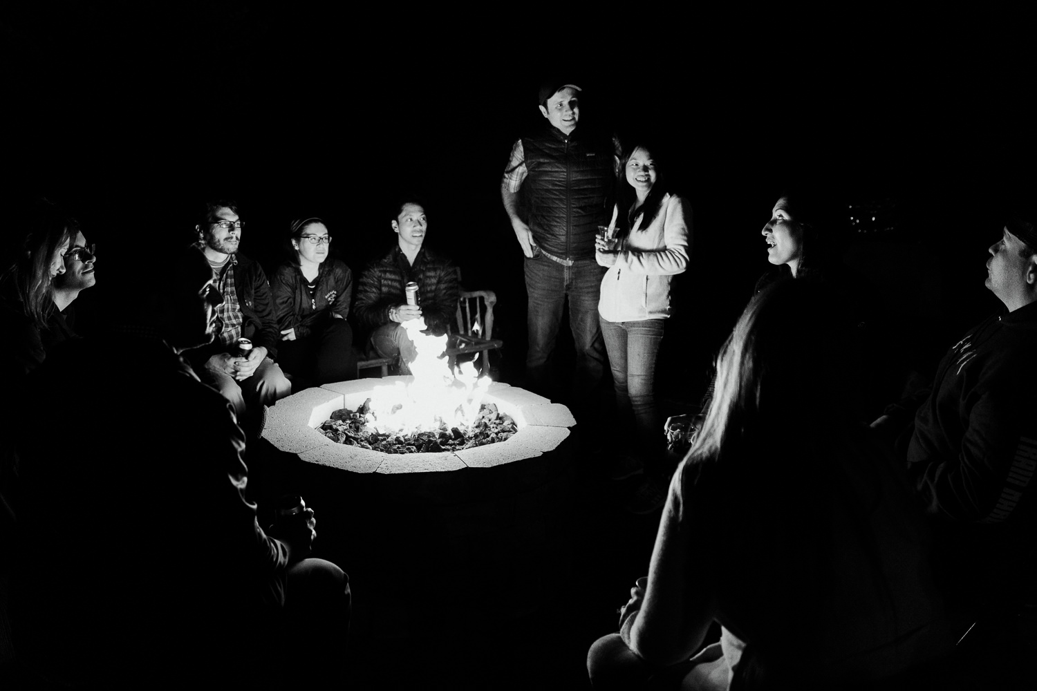guests sitting around a campfire at Gouldsboro Maine campground wedding