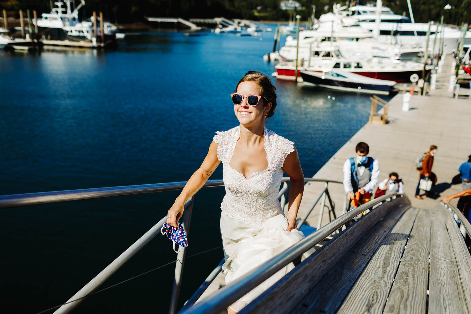 Bride walking up dock for her Sutton Island and Bar Harbor Maine wedding