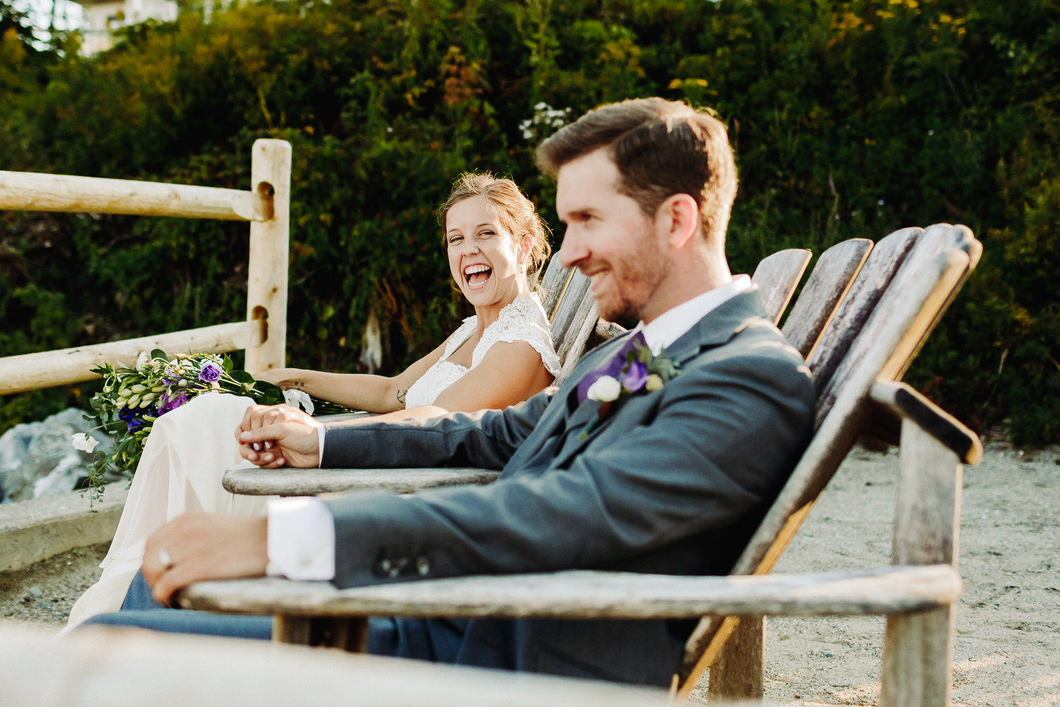 Bride and groom sitting in adirondack chairs at Sutton Island and Bar Harbor Maine wedding