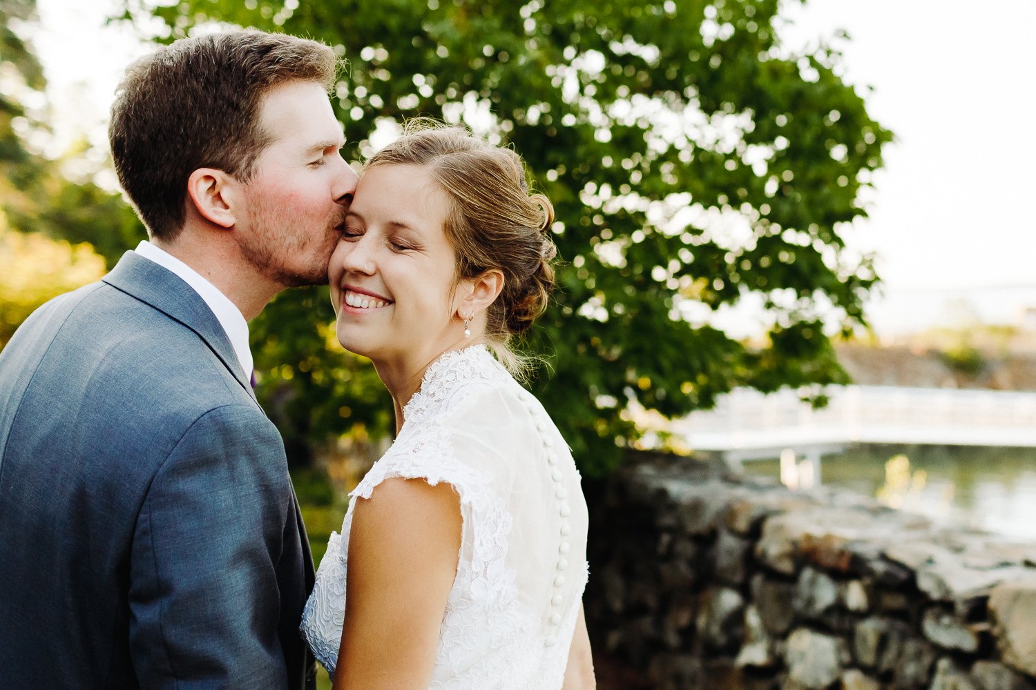 groom kissing bride's forehead at Sutton Island and Bar Harbor Maine wedding