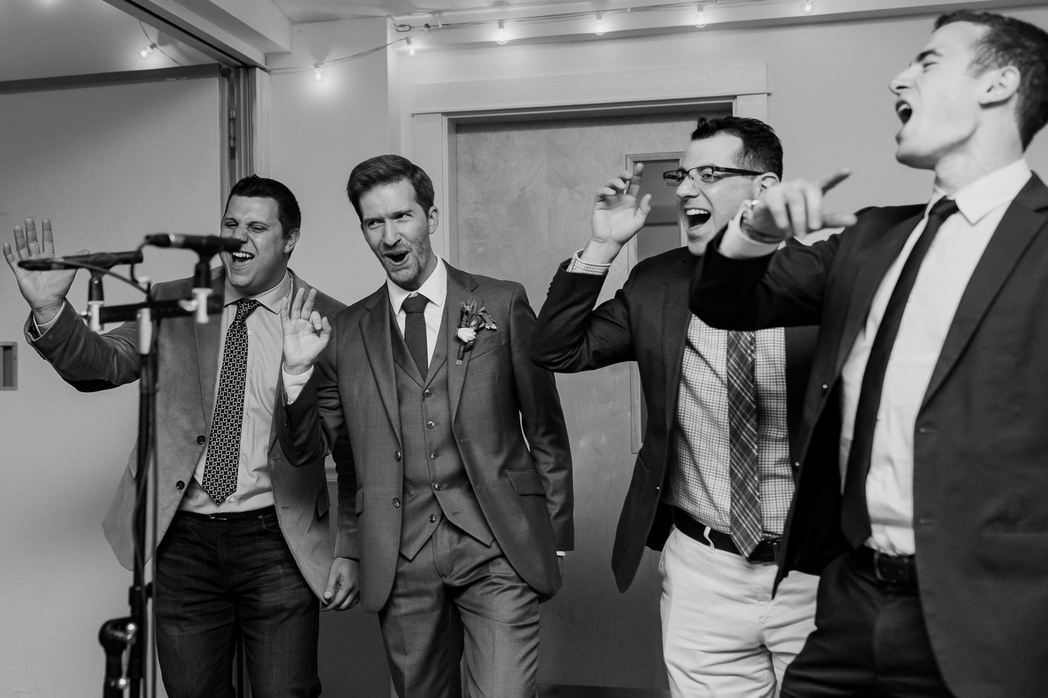 groom singing with a barbershop quartet at his wedding in Bar Harbor