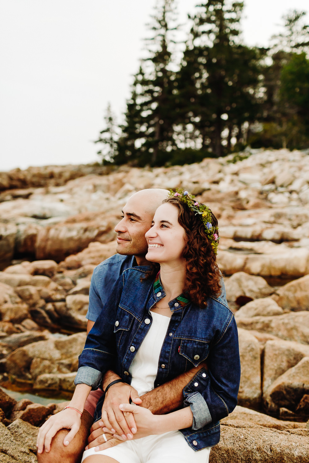 Bride and groom sitting on cliffs at Gouldsboro Maine campground wedding.