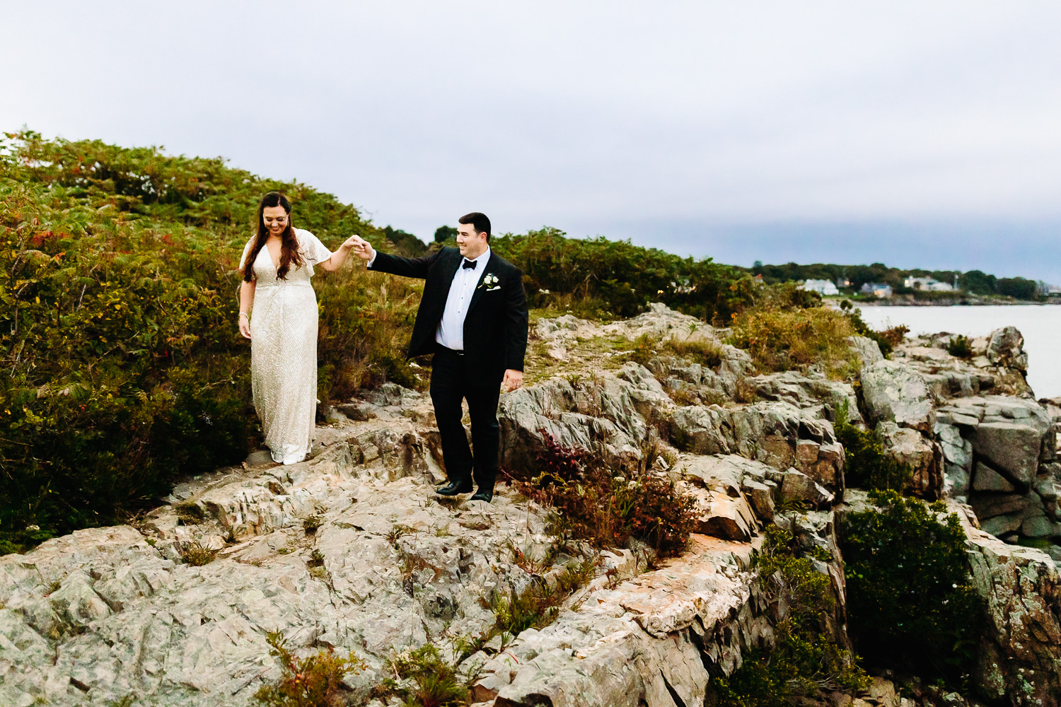 Bride and groom walking on cliffs at Stage Neck Inn wedding in York Maine