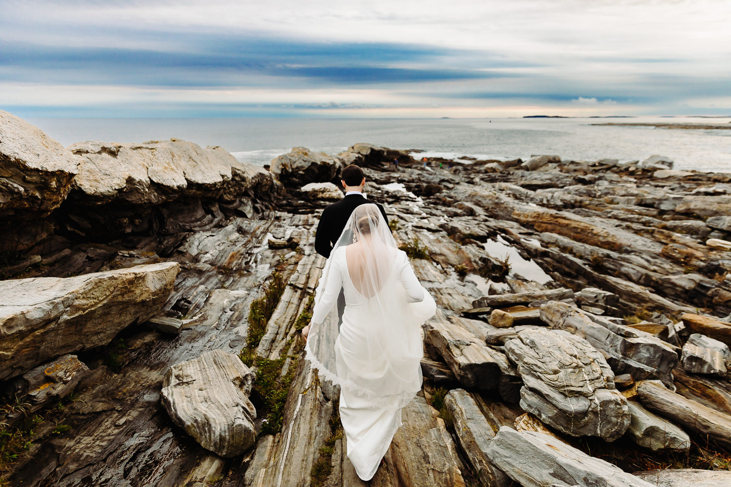 Bride and groom on cliffs at Pemaquid Point Lighthouse during Contented Sole Maine wedding
