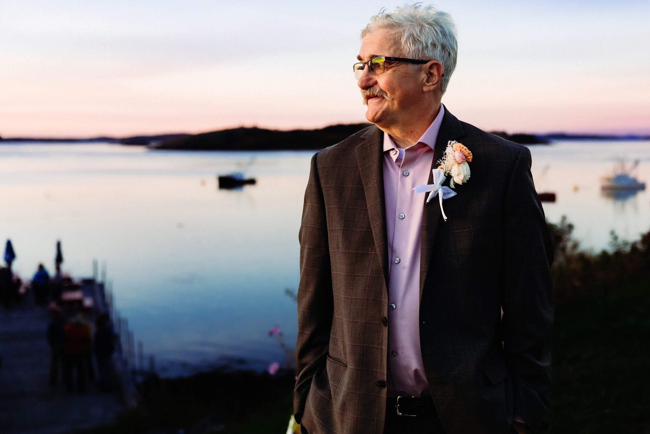 Groom standing in front of sunset in Lubec Maine