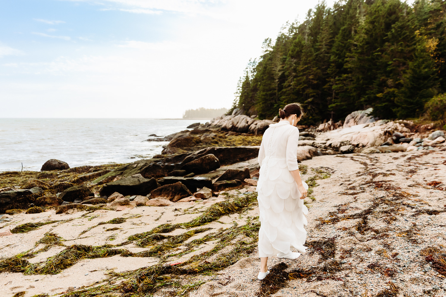 bride walking on beach at Aragosta during Deer Isle Maine wedding