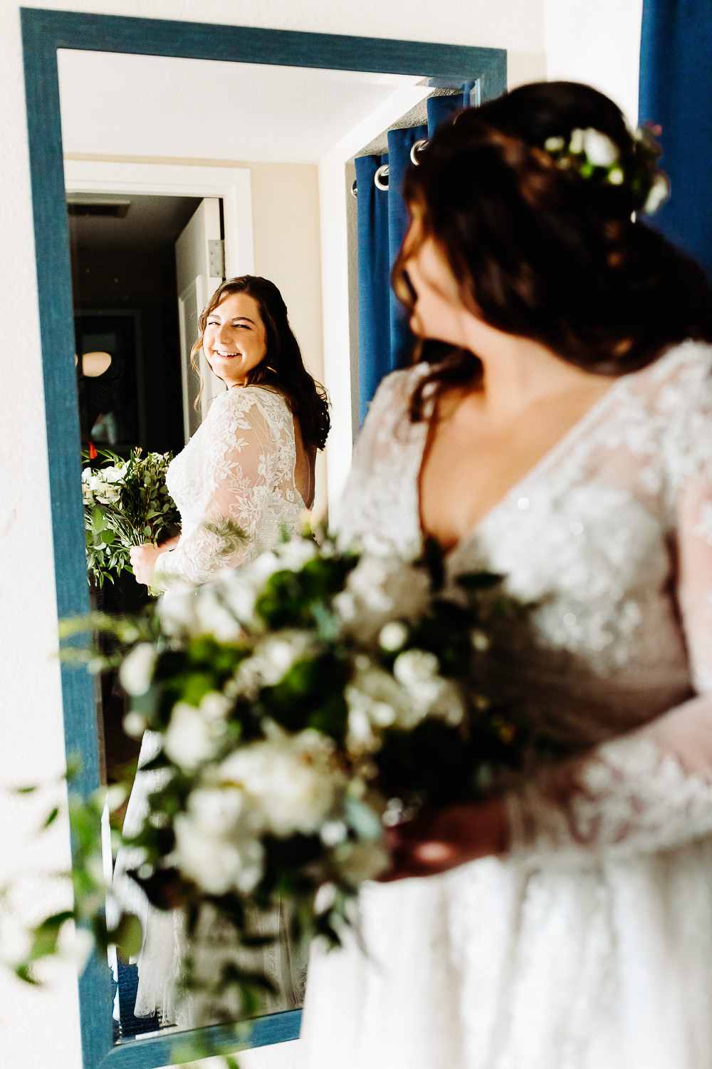 Bride looking in mirror before spring Acadia wedding in Bar Harbor