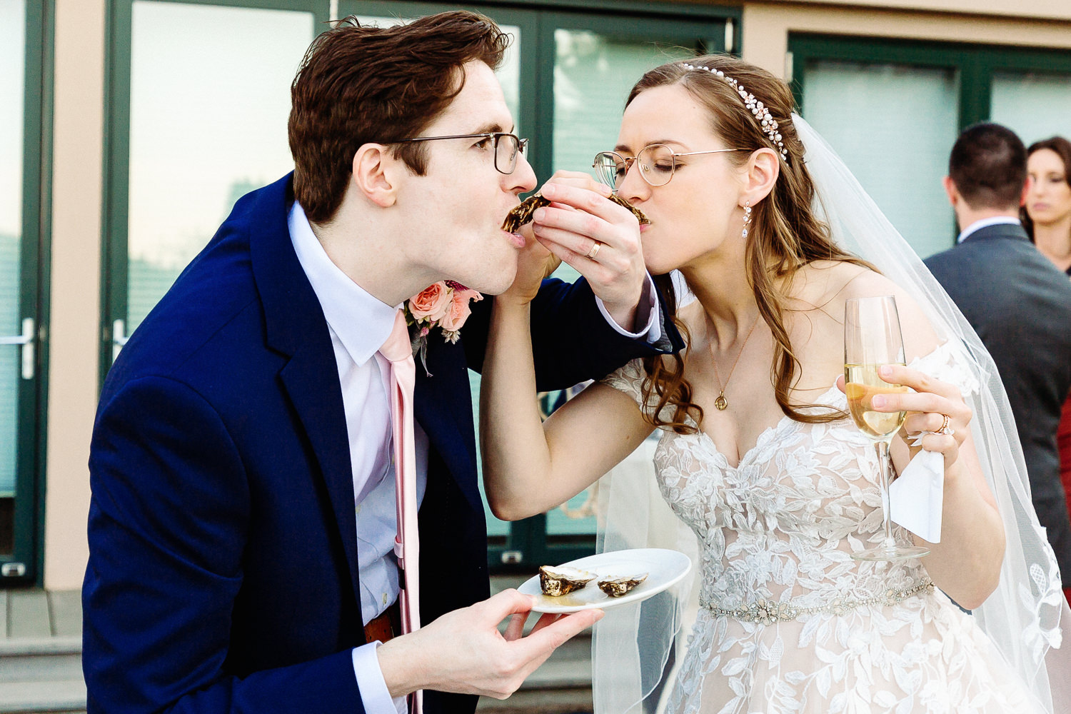 bride and groom shoot oysters at Harborside Hotel wedding