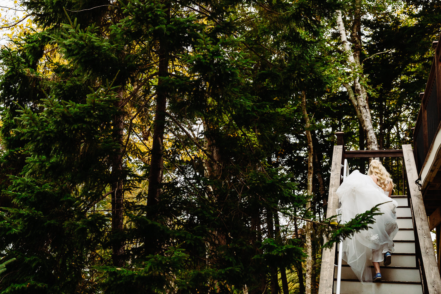 Bride climbing stairs during fall elopement in Acadia National Park