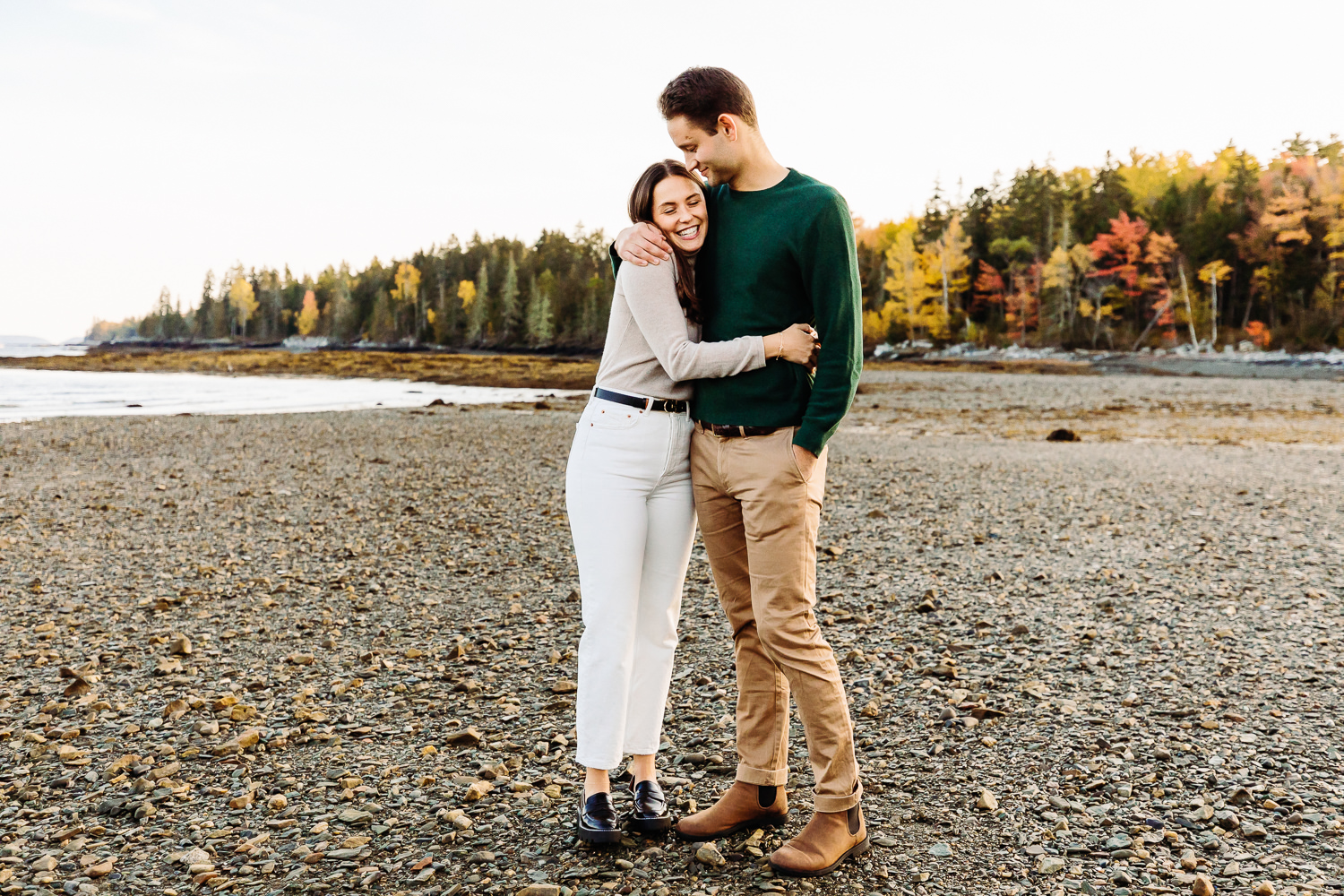 couple embracing on rocky beach during Hancock Point Maine engagement photos