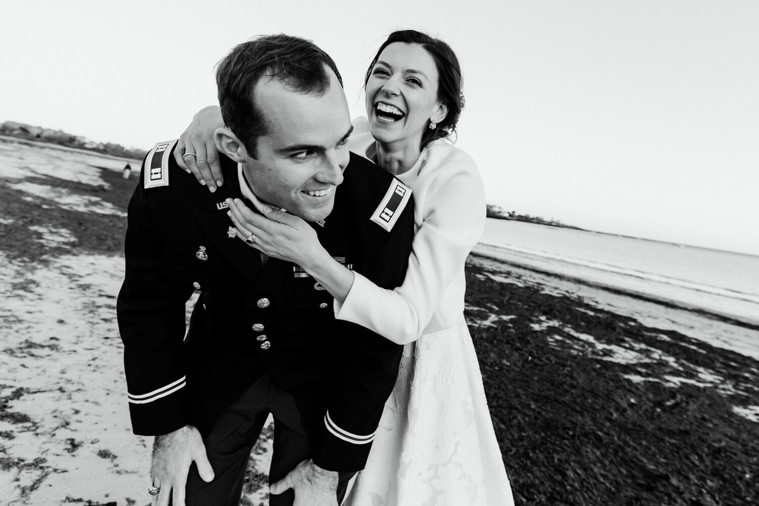 Bride and groom laughing together on beach during portraits at their Cape Elizabeth wedding 