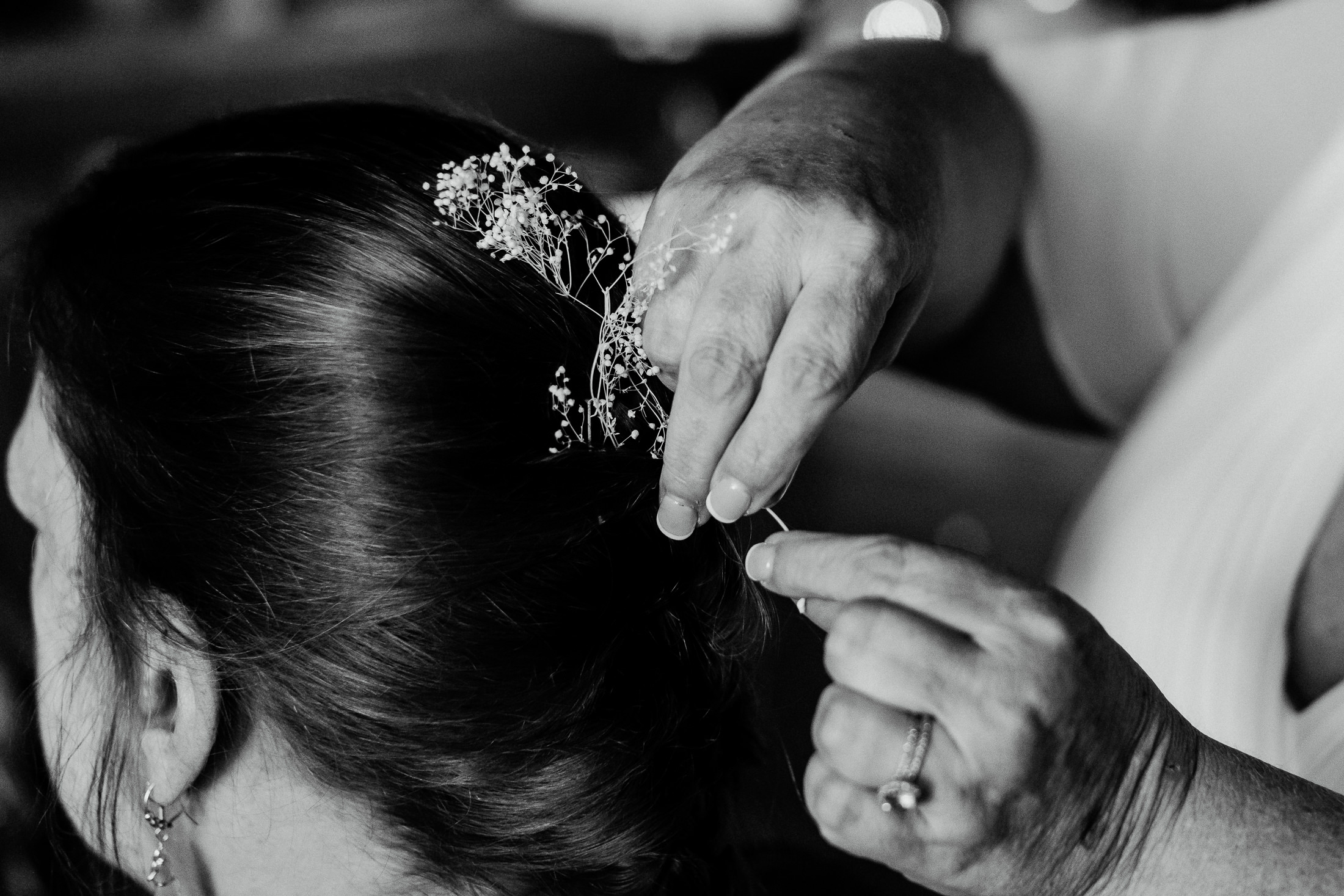 Bride putting flowers in her friend's hair