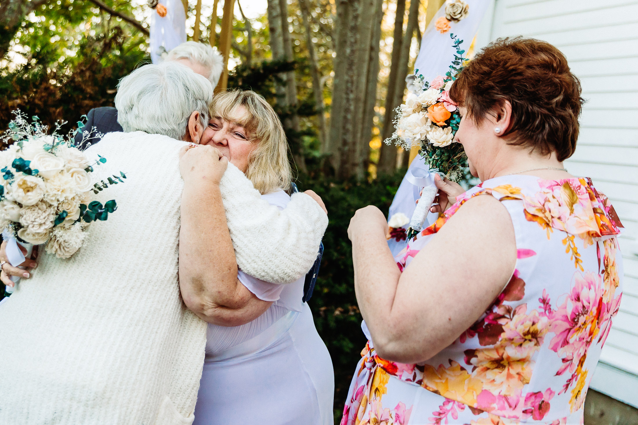 emotional bride hugging groom's mother after wedding ceremony