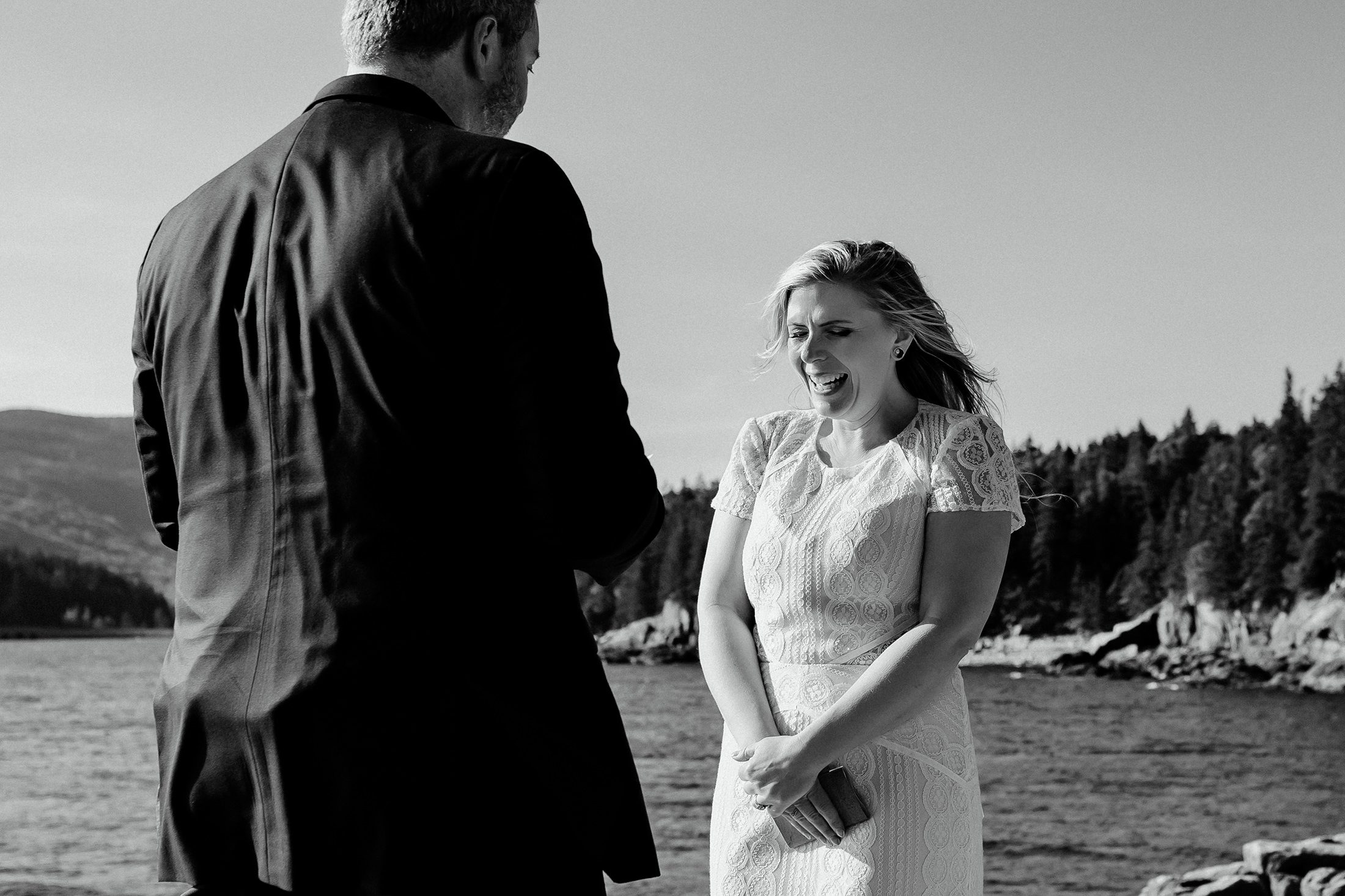 Bride laughing during groom's vows at Otter Point Acadia elopement