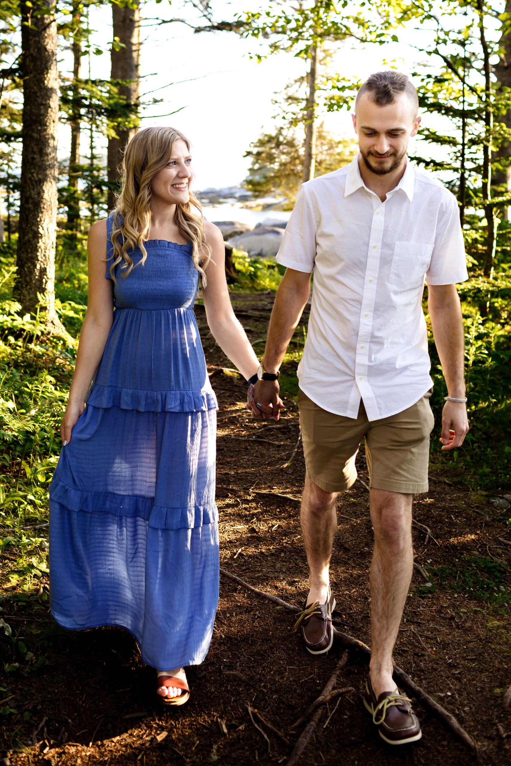 couple walking in woods during Stonington Maine engagement photos