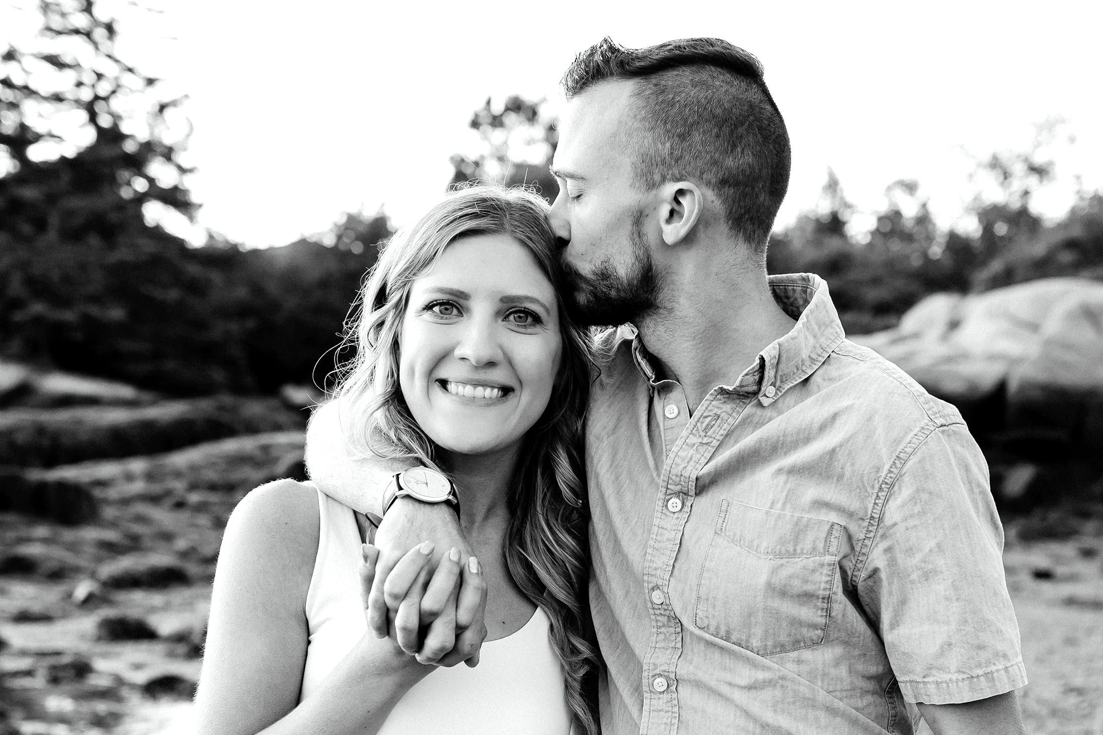 man kissing fiancee's head during Stonington Maine engagement photos