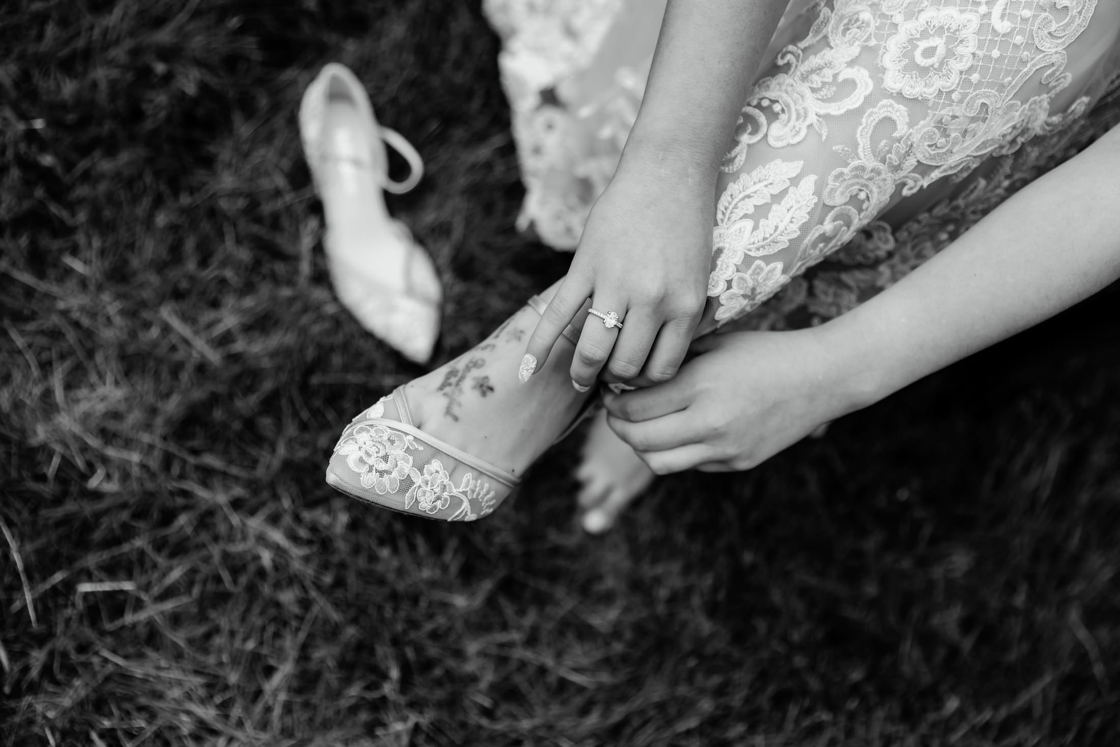 bride buttoning shoes during Under Canvas Acadia wedding in Surry Maine