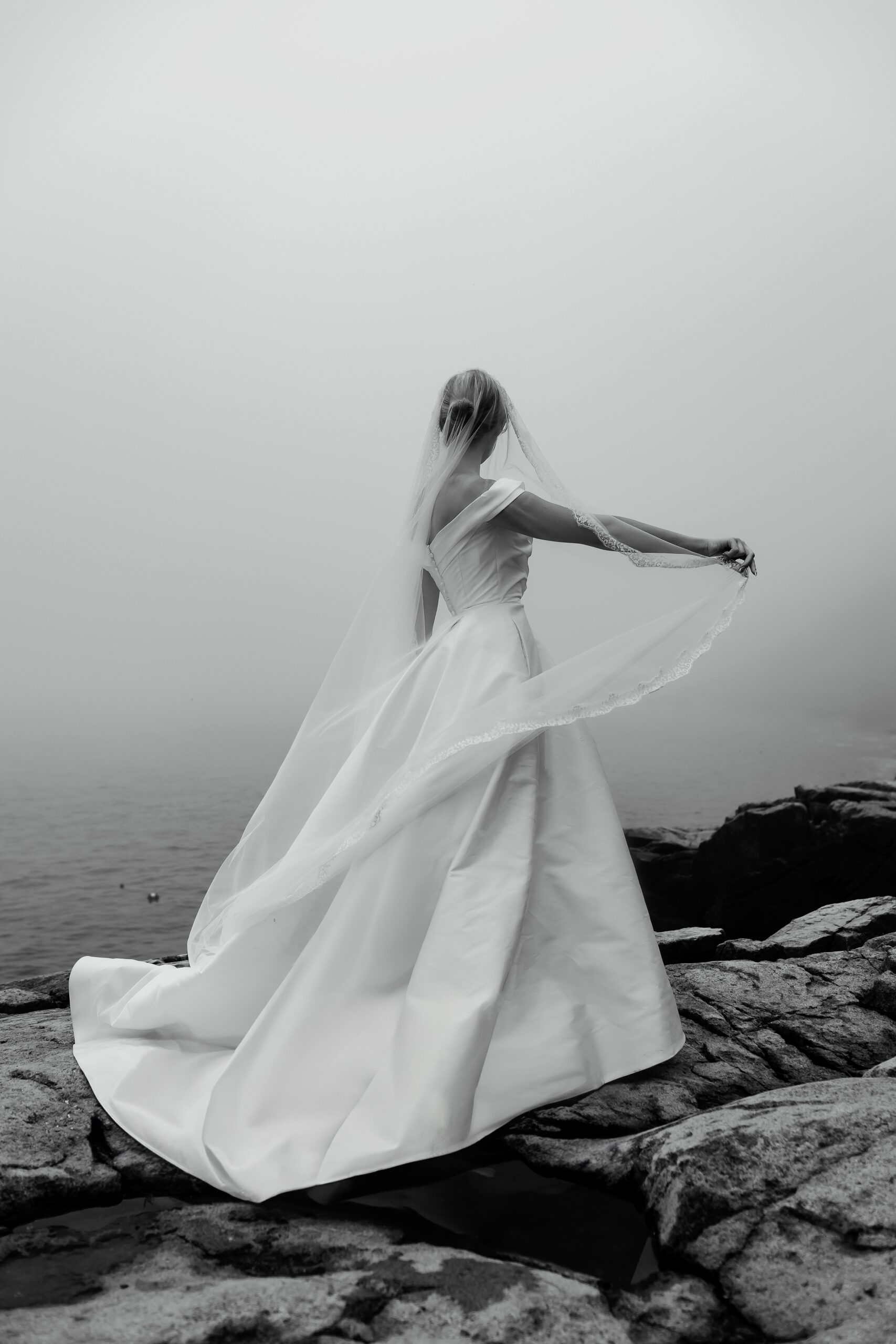bride twirling her veil during foggy wedding portraits in Acadia
