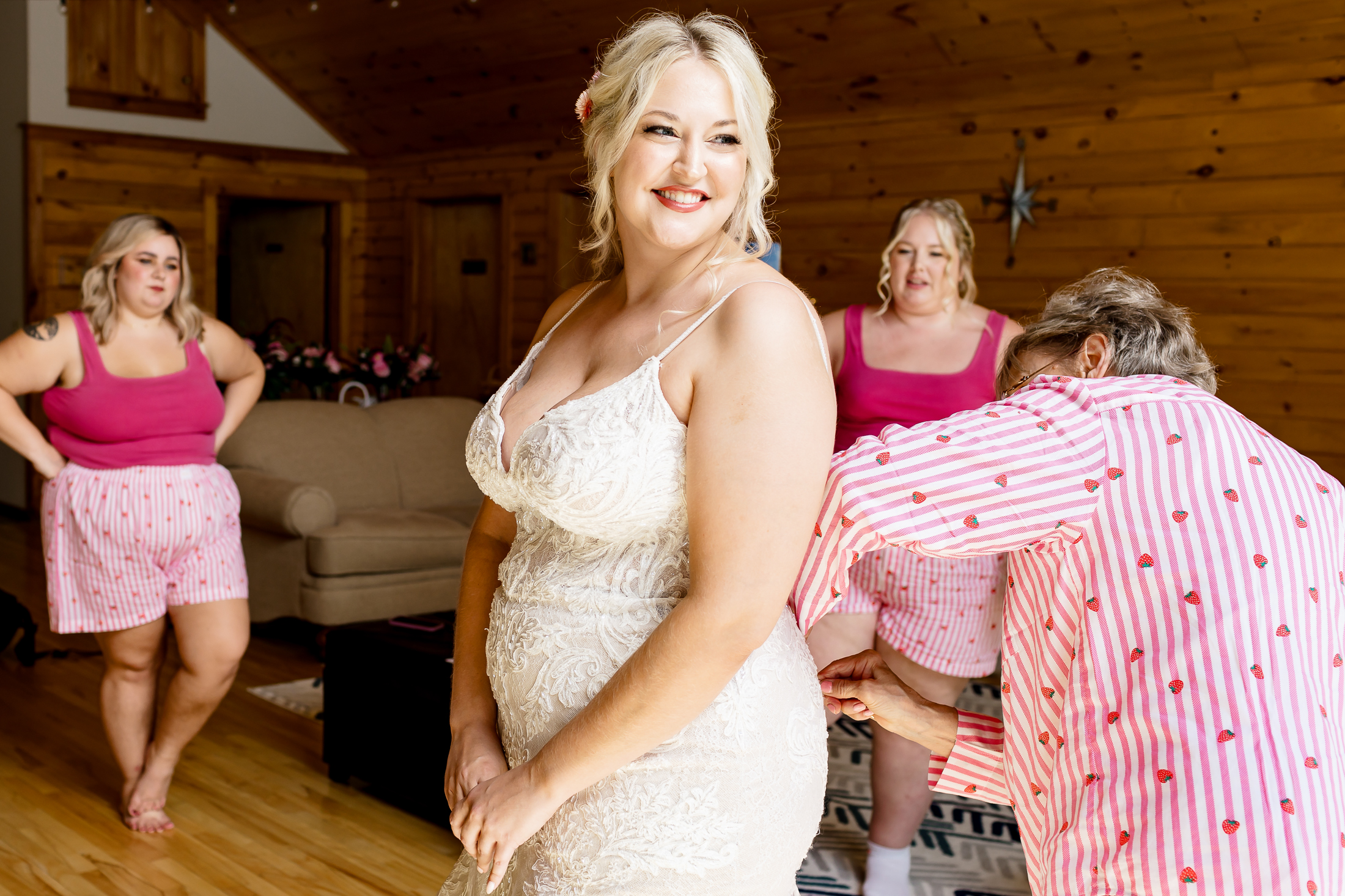 Bride getting buttoned into her dress during Caratunk Maine wedding at Maine Lakeside Cabins