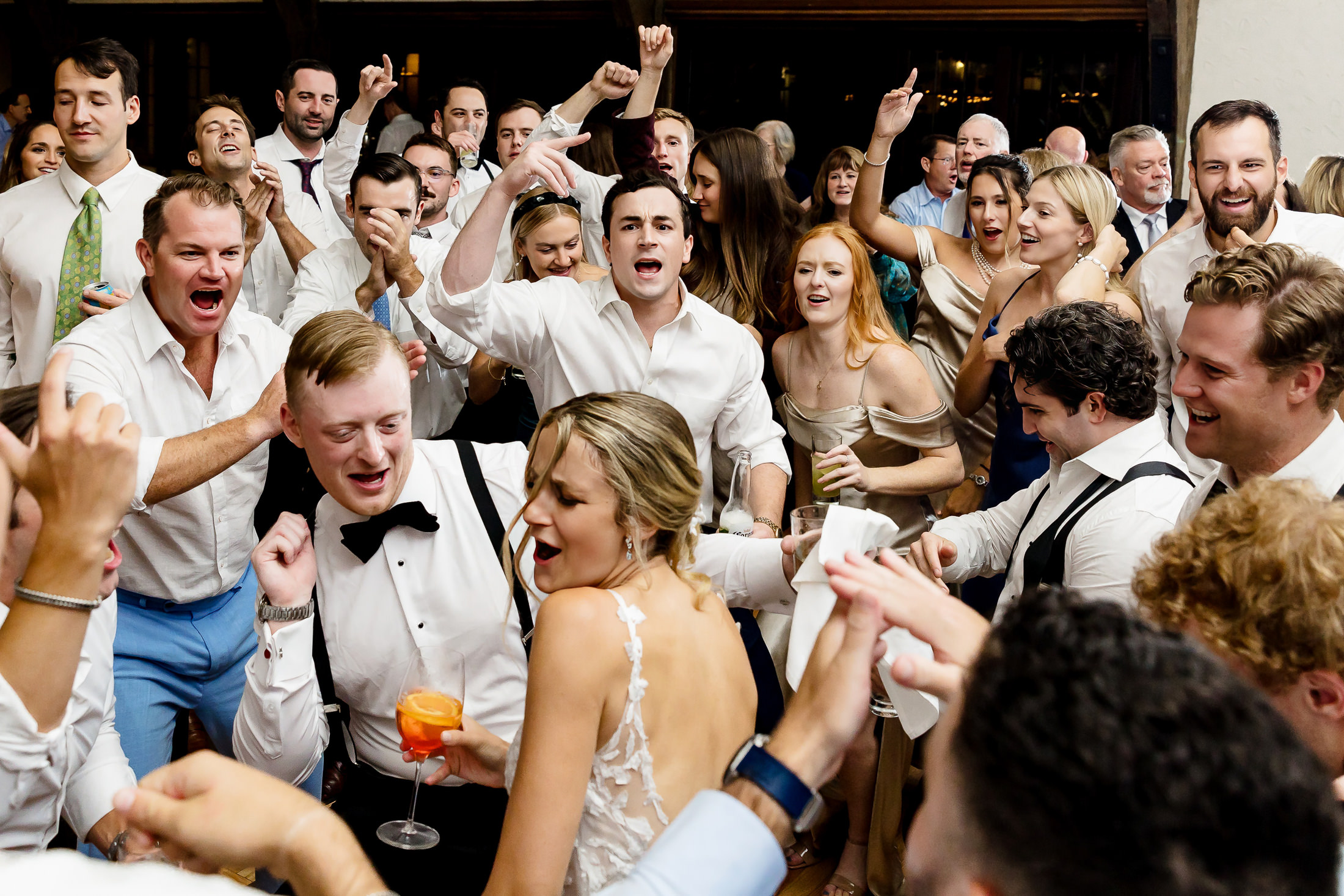 wedding party surrounds the couple on the dance floor at stormy Bar Harbor wedding
