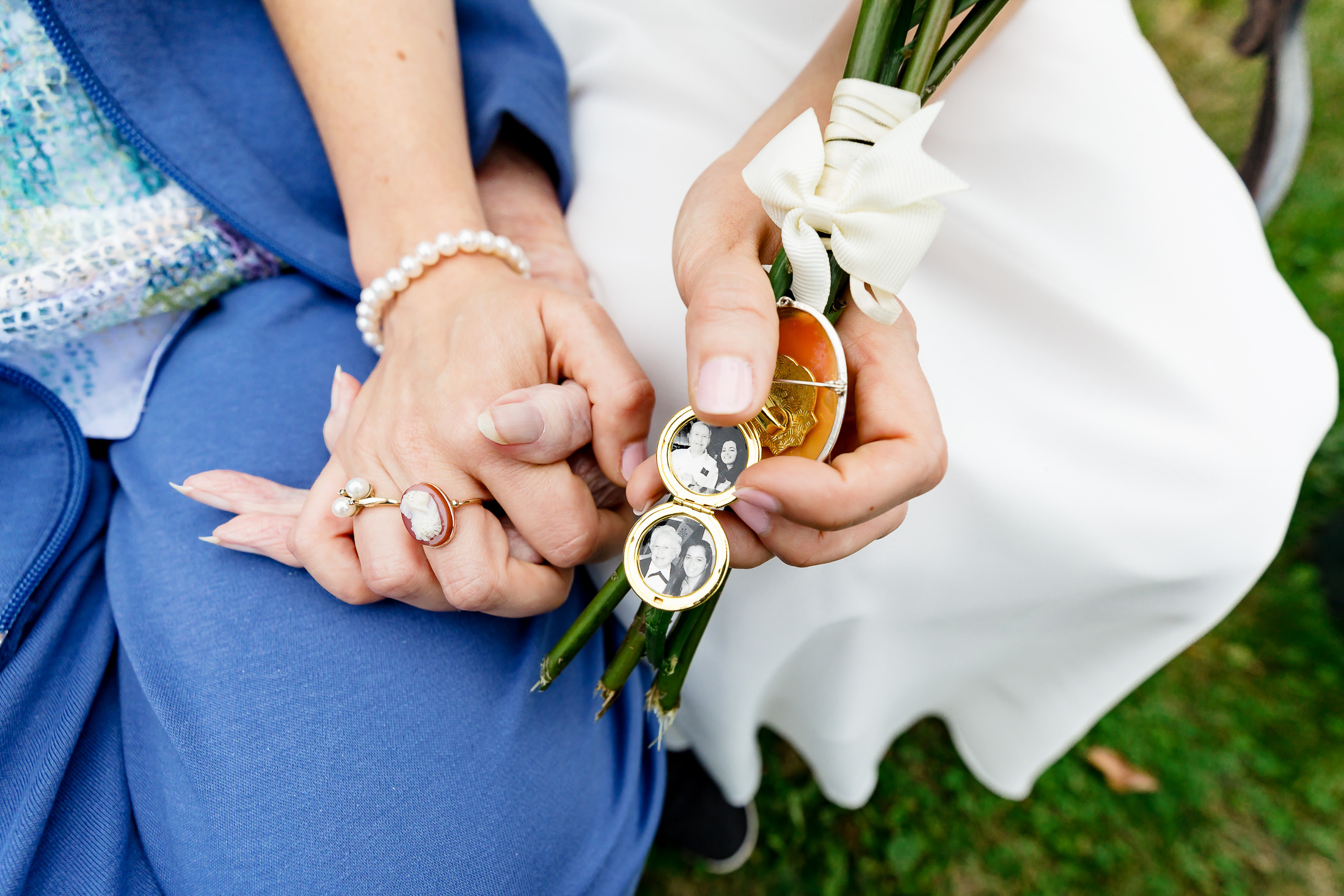 Bride holding her grandmother's hand and a locket of her grandfather after Camden Maine wedding ceremony