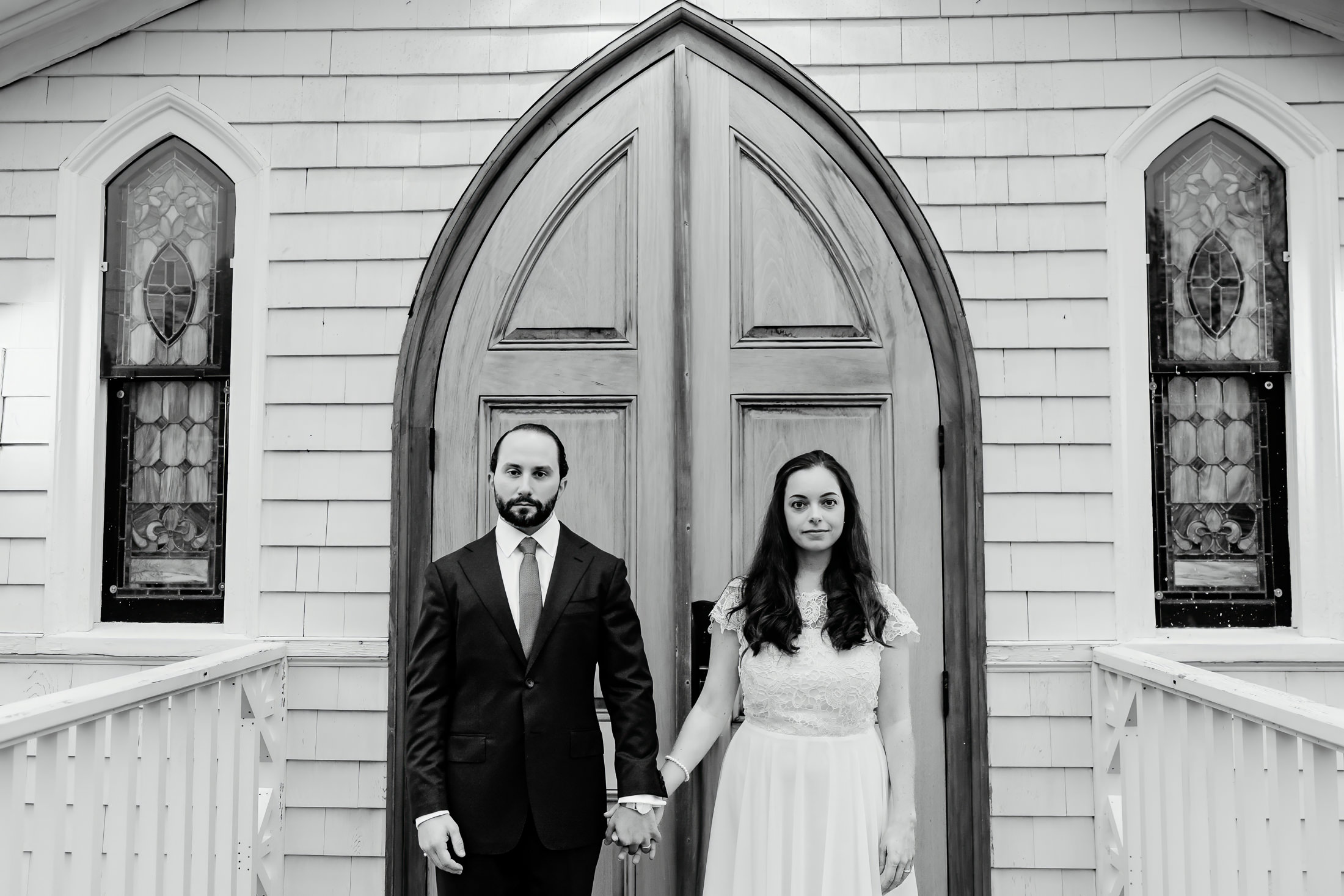 couple holding hands in front of church doors after Camden Maine wedding ceremony