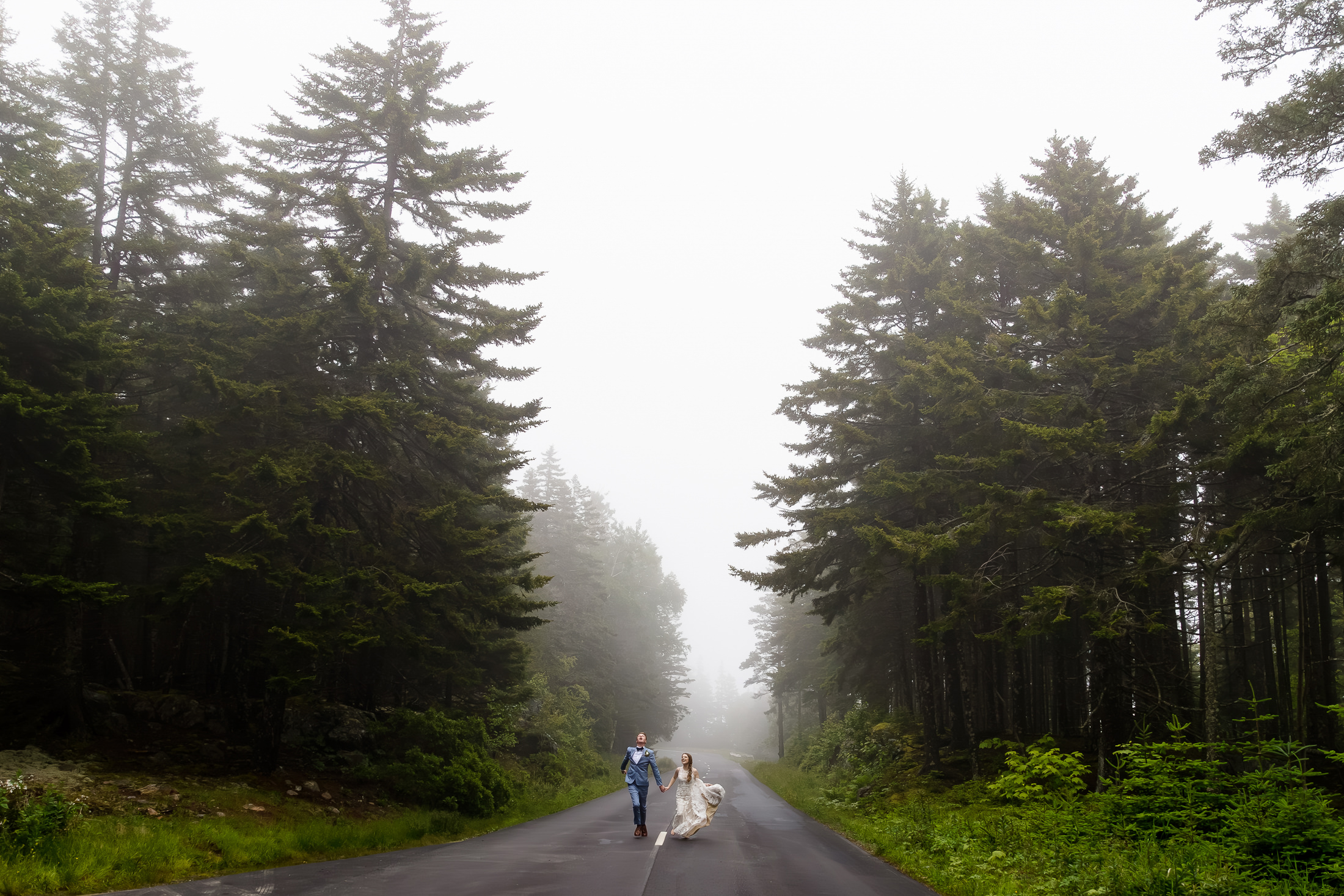 couple running on Park Loop Road in Acadia National Park after their Acadia elopement