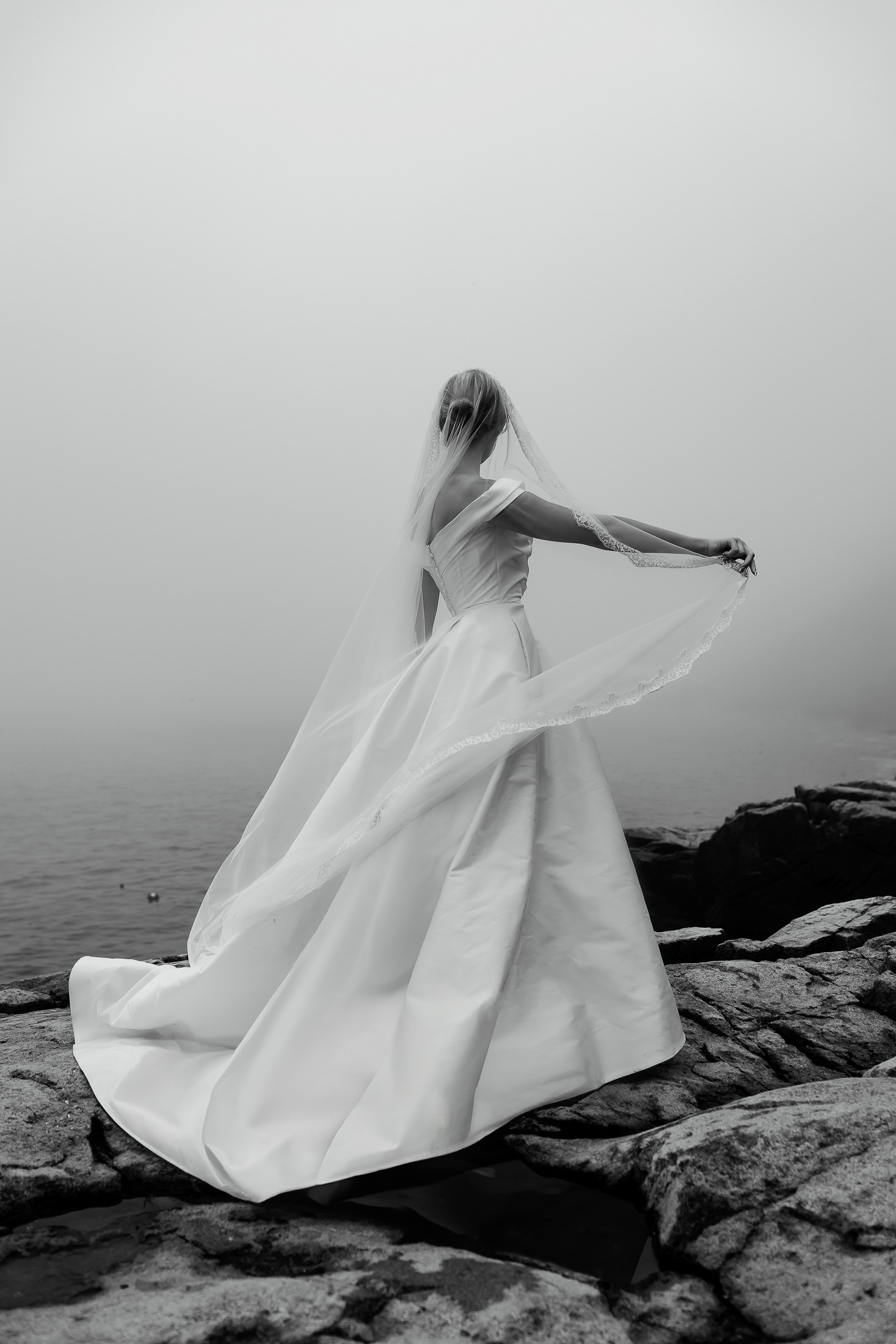 Bride holding her veil during wedding portraits in Acadia National Park