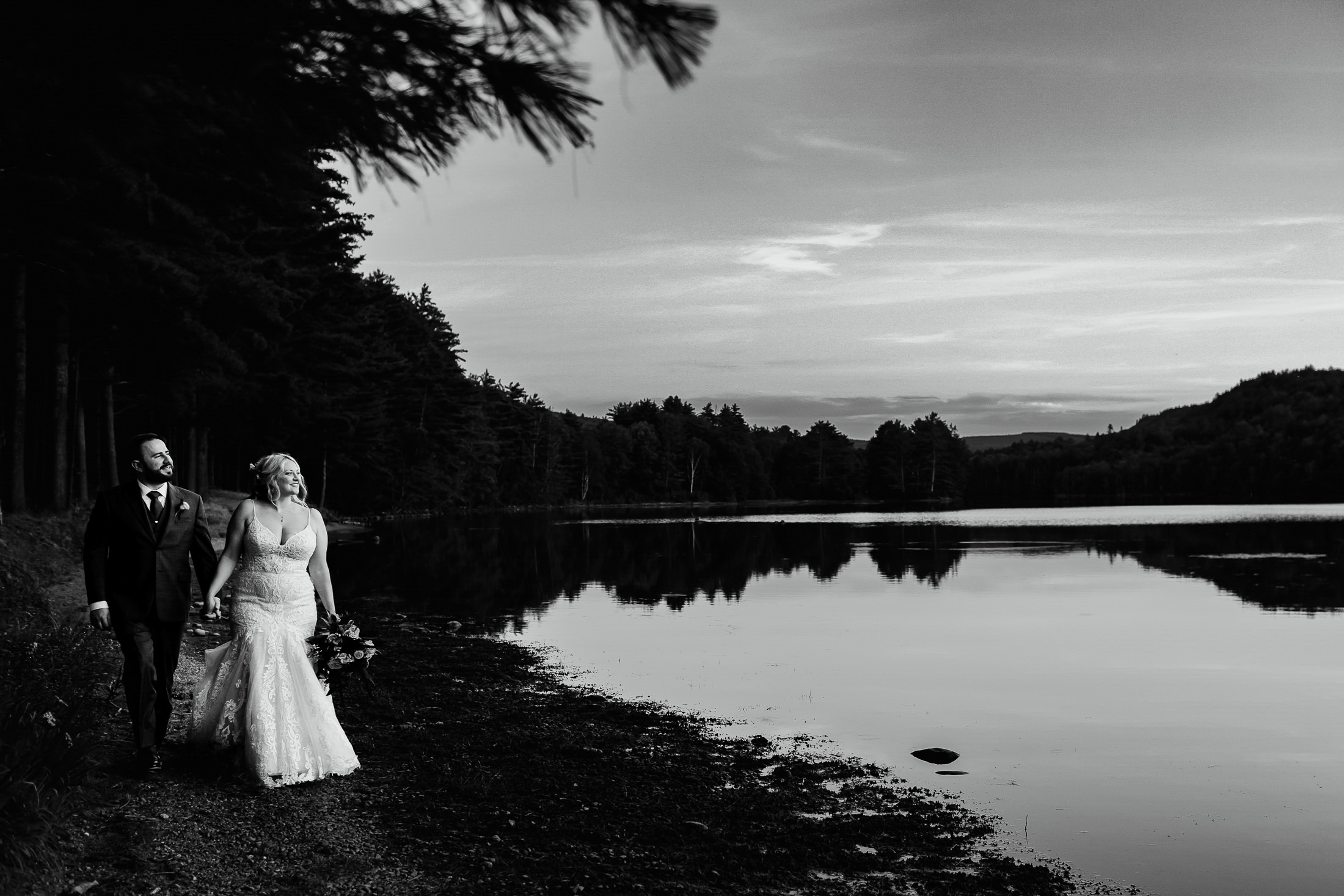 couple walking along the water during Caratunk Maine wedding